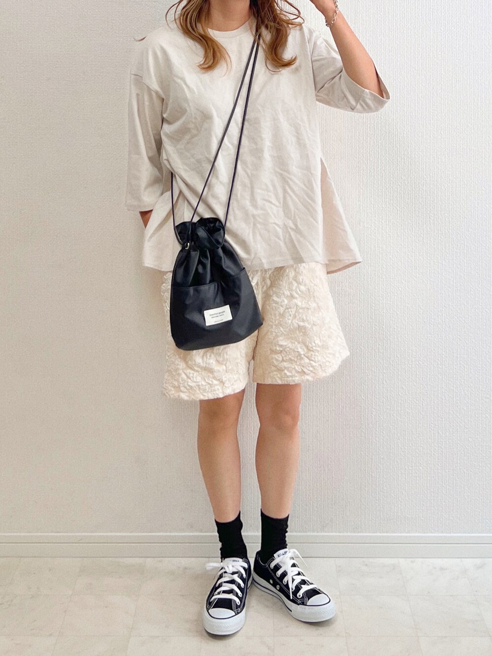 グレー系のTシャツ/カットソー、ベージュ系のその他パンツ、ブラック系のスニーカーを着用したレディースの夏コーディネートの3枚目の写真