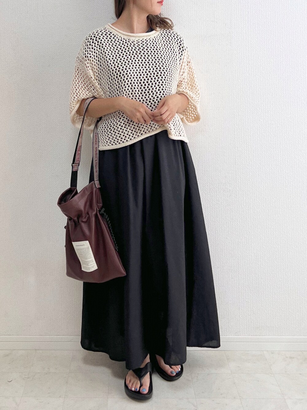 ブラック系のワンピース、ホワイト系のニット/セーター、ブラウン系のショルダーバッグを着用したレディースの夏コーディネートの3枚目の写真
