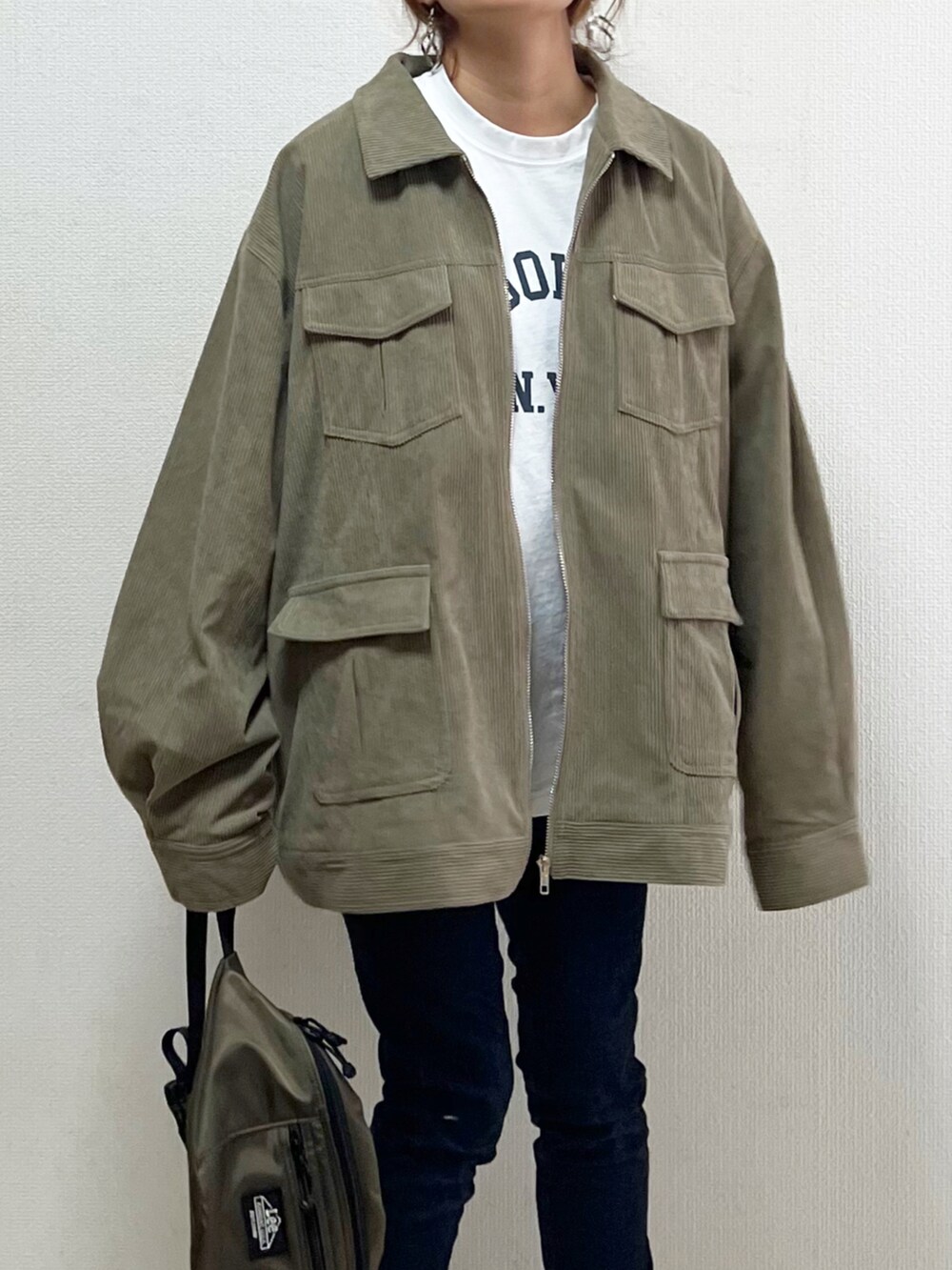 グリーン系のブルゾン、ホワイト系のTシャツ/カットソー、ホワイト系のスニーカーを着用したレディースの秋コーディネートの4枚目の写真