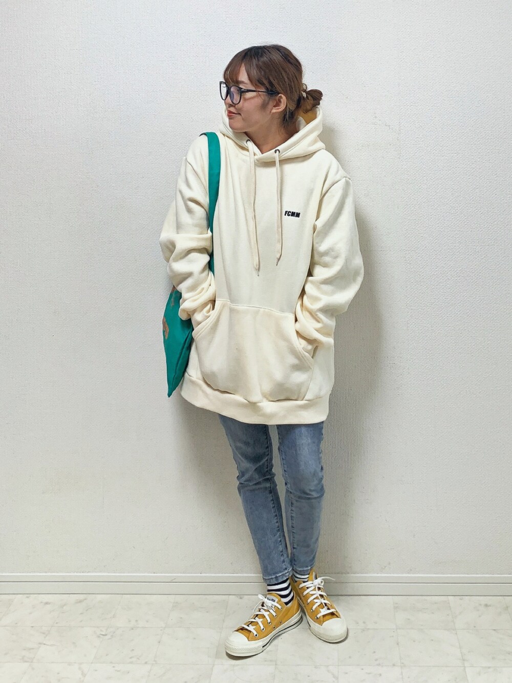 ベージュ系のパーカー、グリーン系のショルダーバッグ、オレンジ系のパンツを着用したレディースの春コーディネートの3枚目の写真