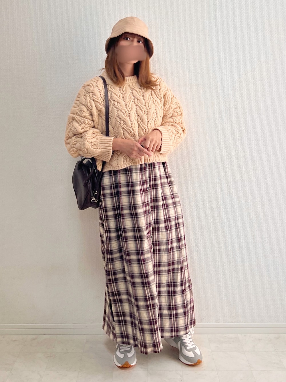 ベージュ系のニット/セーター、ブラウン系のボストンバッグ、レッド系のワンピースを着用したレディースの秋コーディネートの2枚目の写真