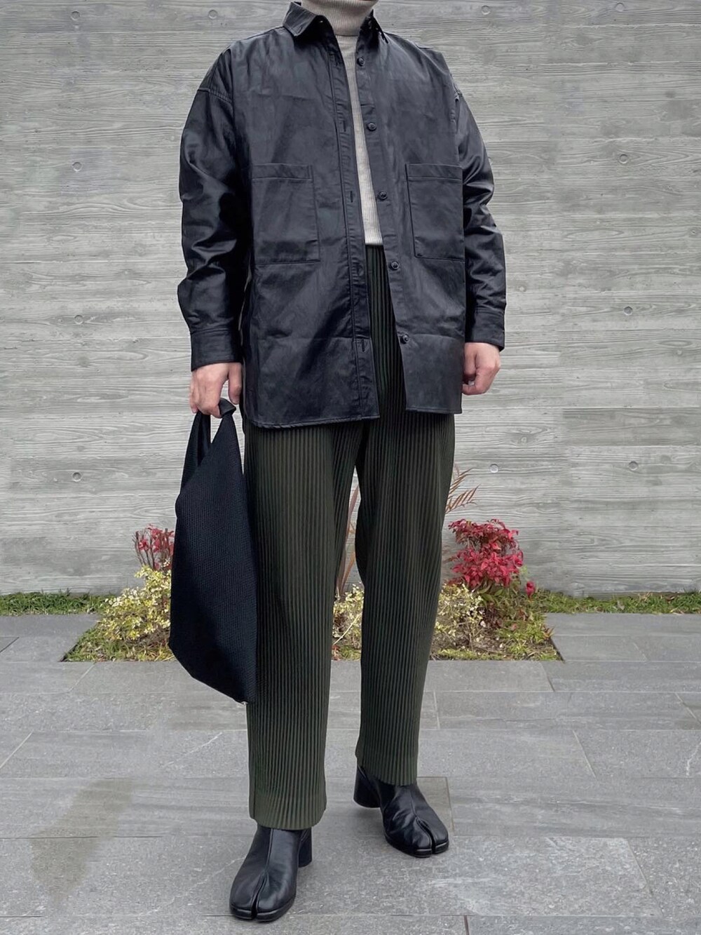 ブラック系のシャツ/ブラウス、ホワイト系のニット/セーター、ブラック系のハンドバッグを着用したメンズの冬コーディネートの2枚目の写真