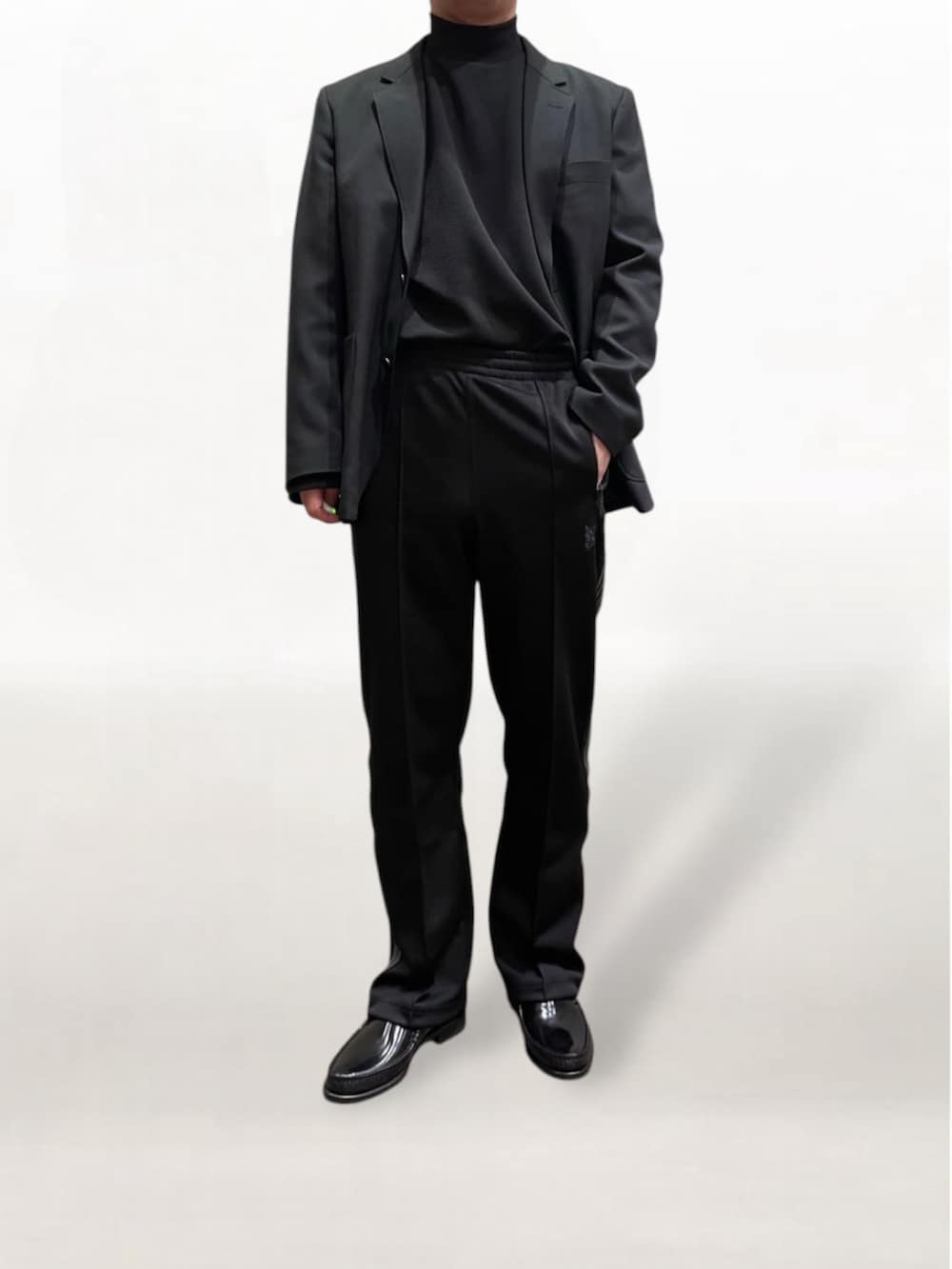 ブラック系のローファー、ブラック系のその他パンツ、ブラック系のテーラードジャケットを着用したメンズの冬コーディネートの2枚目の写真