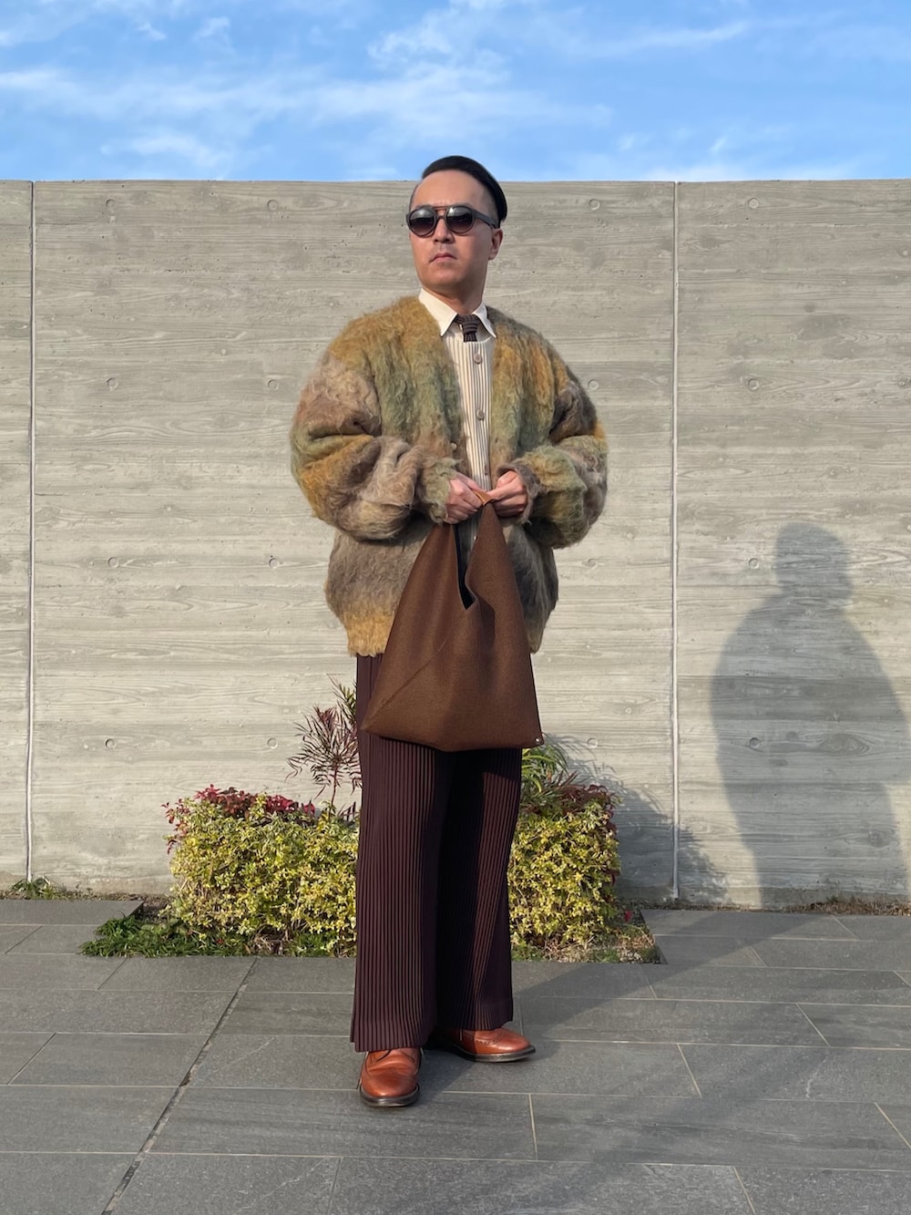 イエロー系のカーディガン/ボレロ、ブラウン系のその他パンツ、ブラウン系のバッグを着用したメンズの冬コーディネートの2枚目の写真