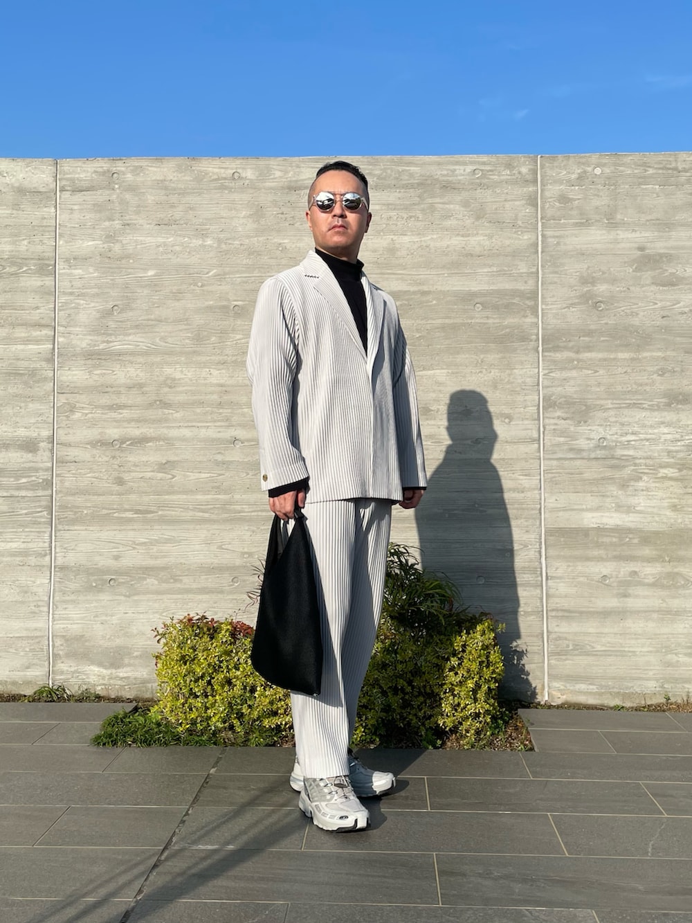 グレー系のその他パンツ、グレー系のテーラードジャケット、ブラック系のトートバッグを着用したメンズの春コーディネートの2枚目の写真