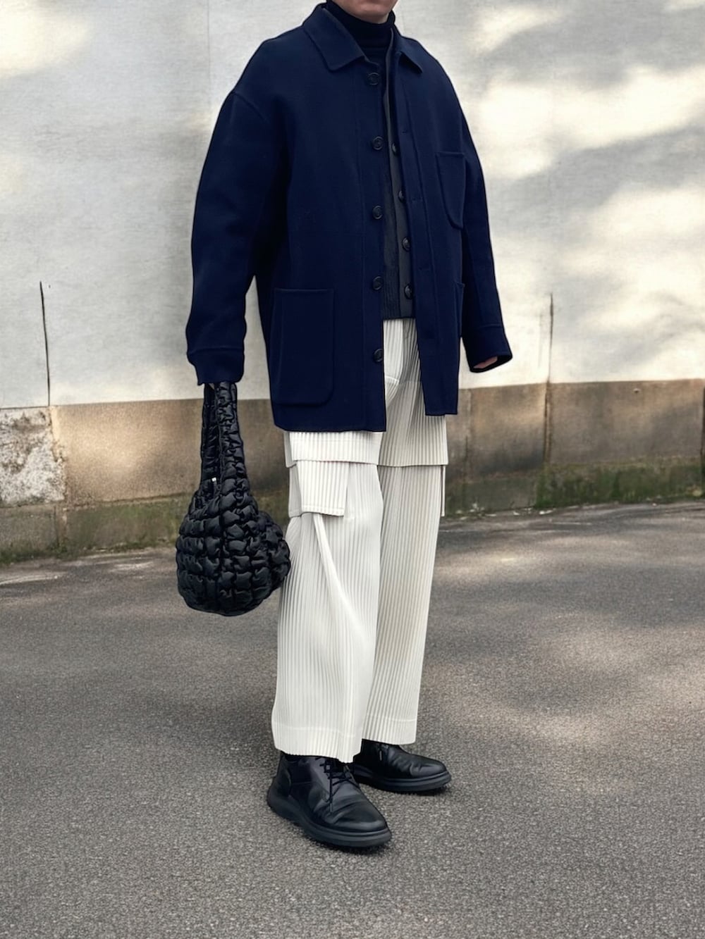 ブルー系のカバーオール、ブラック系のハンドバッグ、ホワイト系のカーゴパンツを着用したメンズの冬コーディネートの3枚目の写真