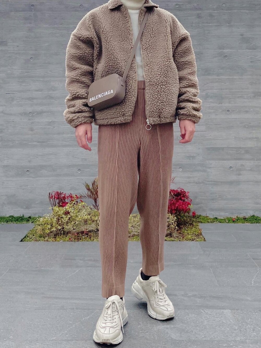 ベージュ系のブルゾン、グレー系のショルダーバッグ、ベージュ系のスラックスを着用したメンズの冬コーディネートの2枚目の写真