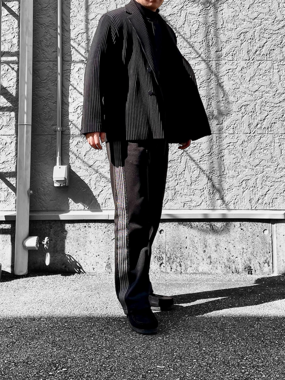 ブラック系のブーツ、ブラック系のベスト、ブラック系のテーラードジャケットを着用したメンズの春コーディネートの3枚目の写真