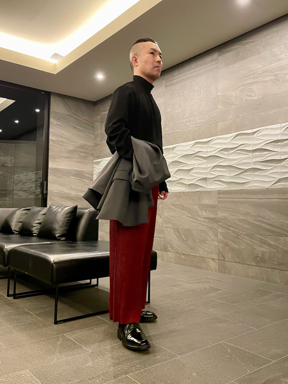 ブラック系のTシャツ/カットソー、グレー系のテーラードジャケット、レッド系のその他パンツを着用したメンズの秋コーディネートの2枚目の写真