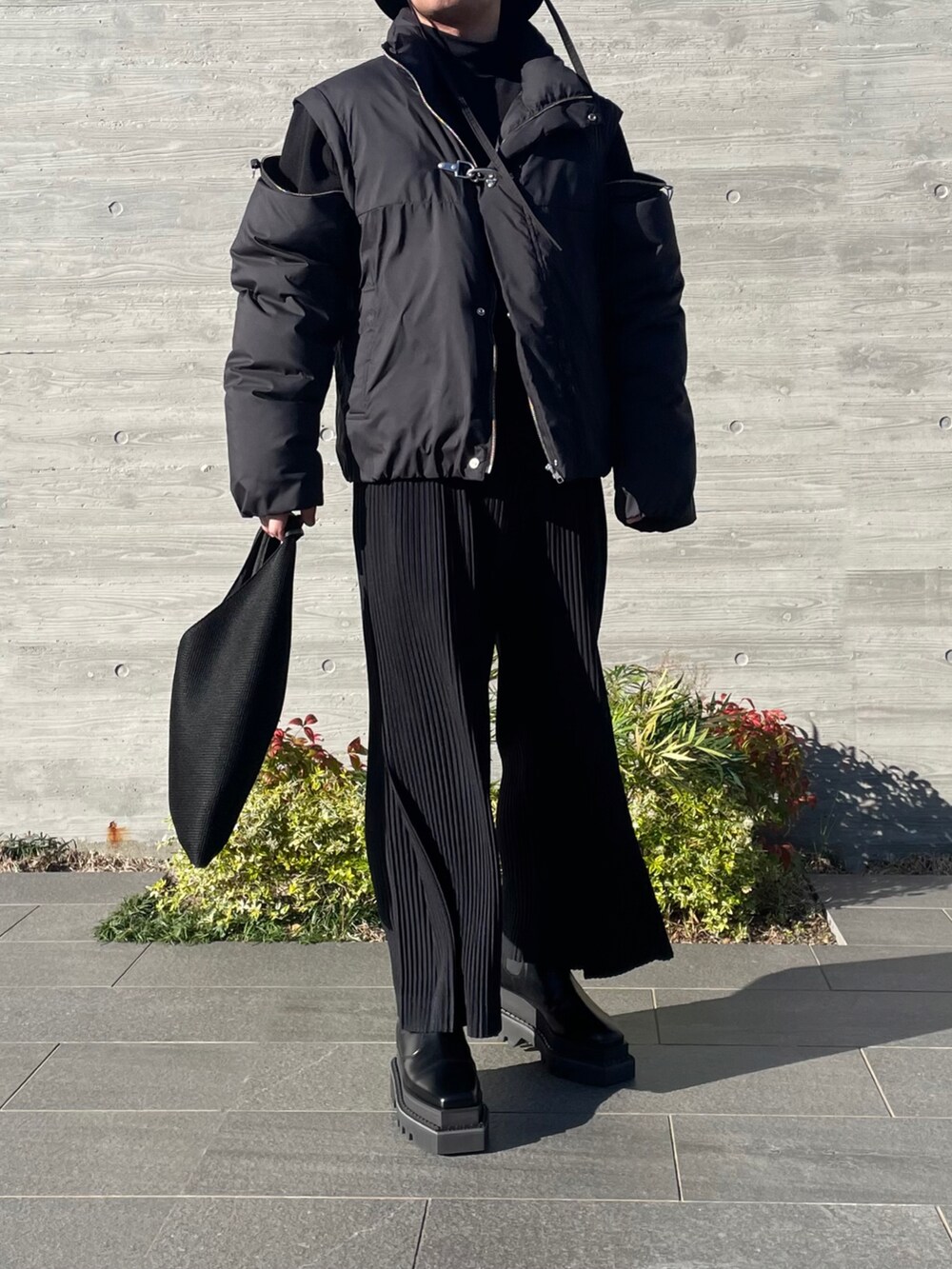 ブラック系のその他アウター、ブラック系のトートバッグ、ブラック系のその他パンツを着用したメンズの秋コーディネートの3枚目の写真