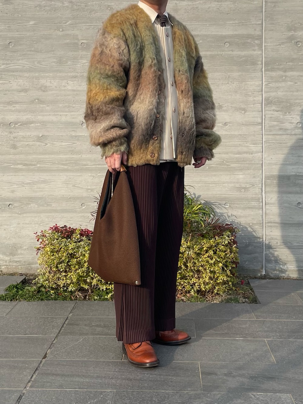 イエロー系のカーディガン/ボレロ、ブラウン系のその他パンツ、ブラウン系のバッグを着用したメンズの冬コーディネートの3枚目の写真