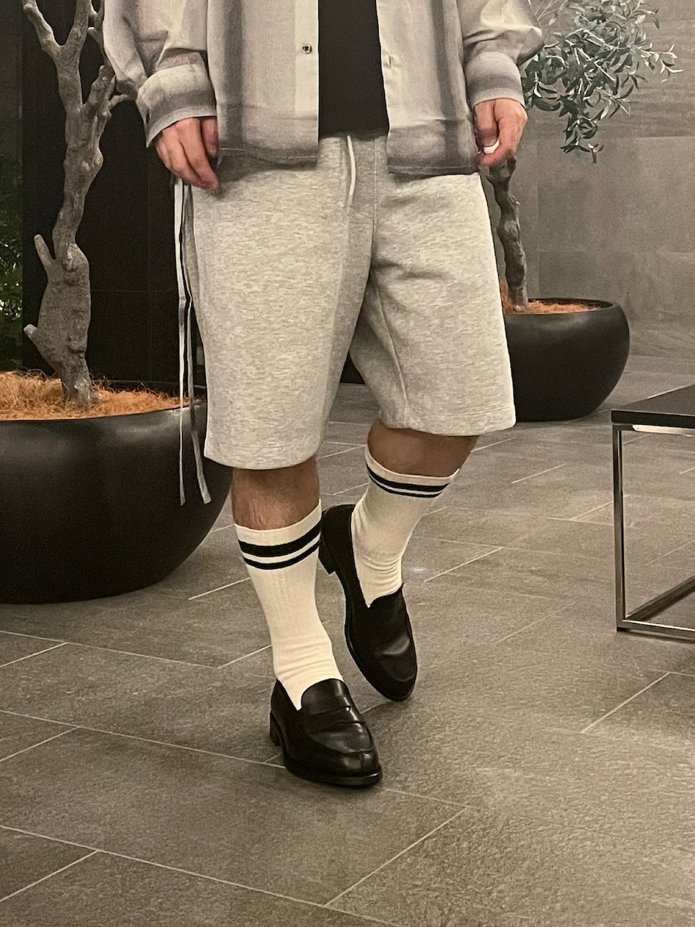 ホワイト系のシャツ/ブラウス、グレー系のスウェットパンツ、ブラック系のローファーを着用したメンズの夏コーディネートの3枚目の写真