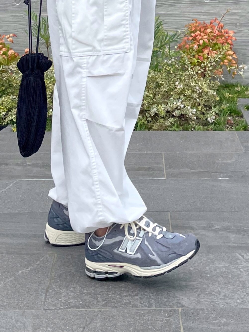 ブラック系のベスト、ブラック系のショルダーバッグ、グレー系のスニーカーを着用したメンズの秋コーディネートの3枚目の写真