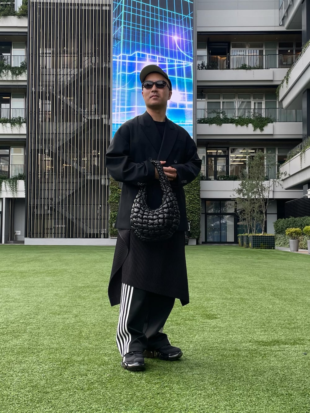 ブラック系のテーラードジャケット、ブラック系のハンドバッグ、ブラック系のその他パンツを着用したメンズの秋コーディネートの4枚目の写真