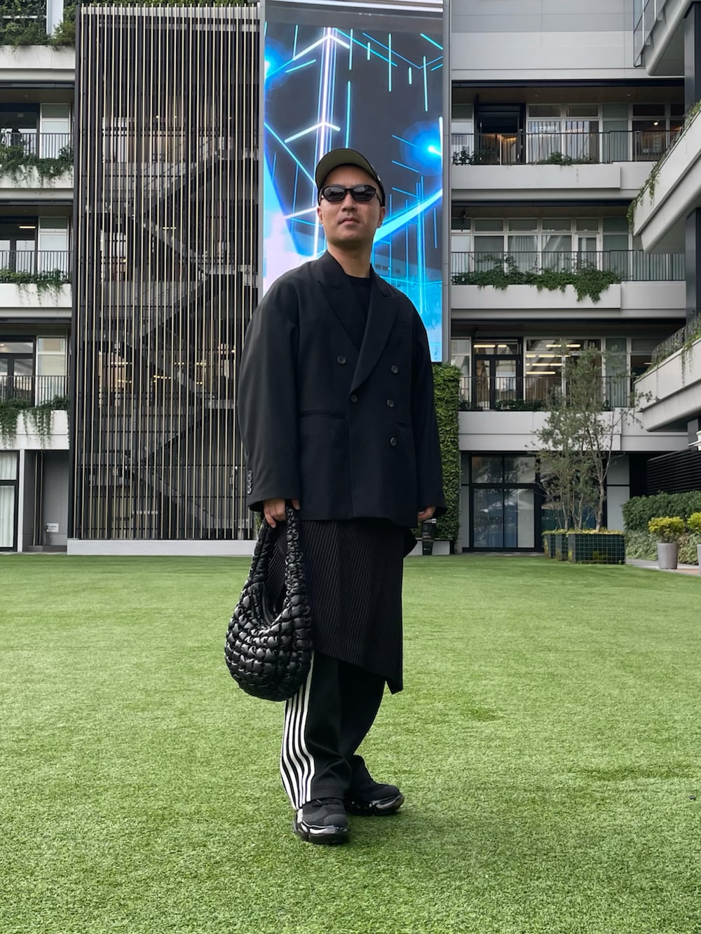 ブラック系のテーラードジャケット、ブラック系のハンドバッグ、ブラック系のその他パンツを着用したメンズの秋コーディネートの3枚目の写真