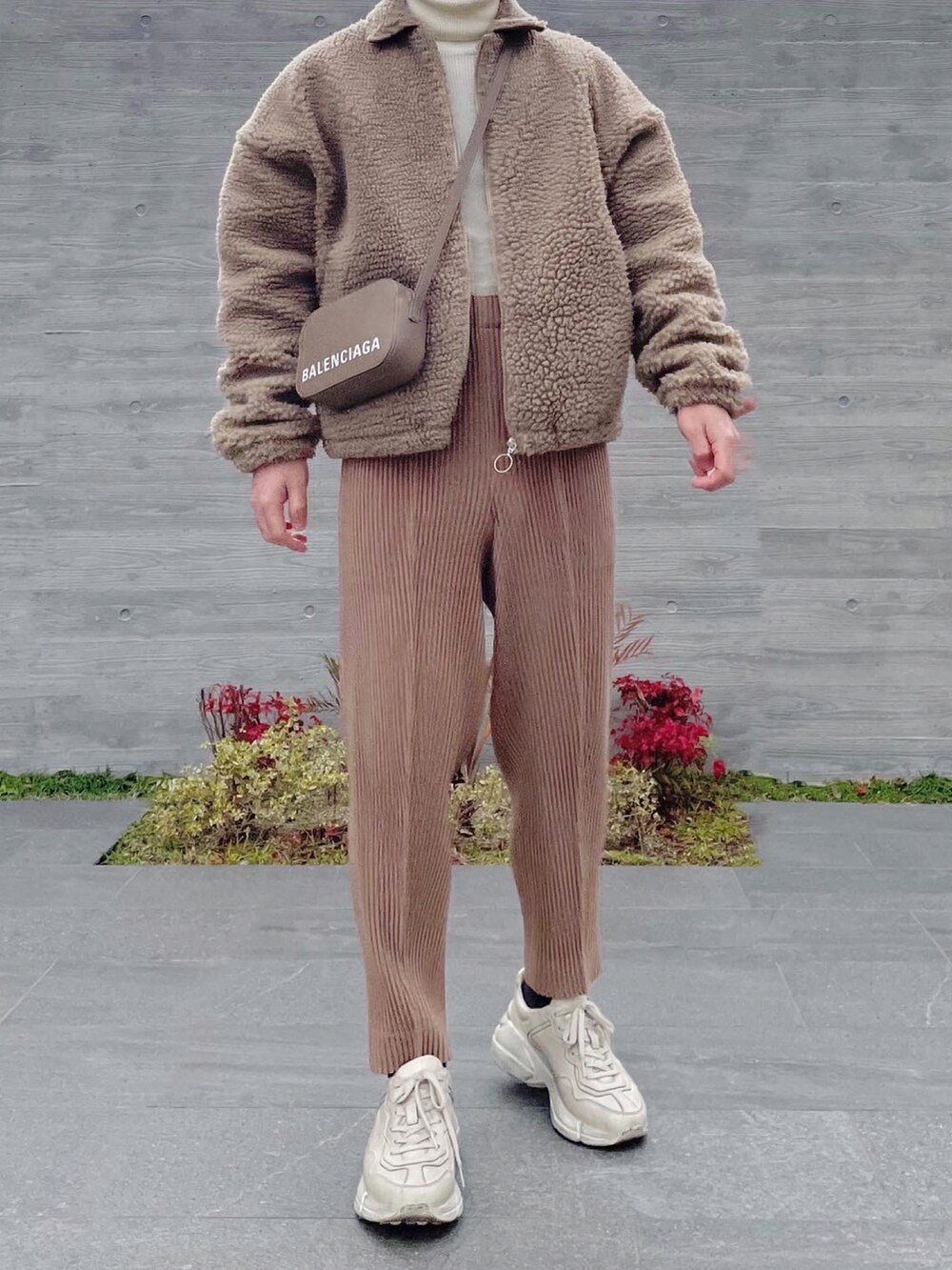 ベージュ系のブルゾン、グレー系のショルダーバッグ、ベージュ系のスラックスを着用したメンズの冬コーディネートの3枚目の写真