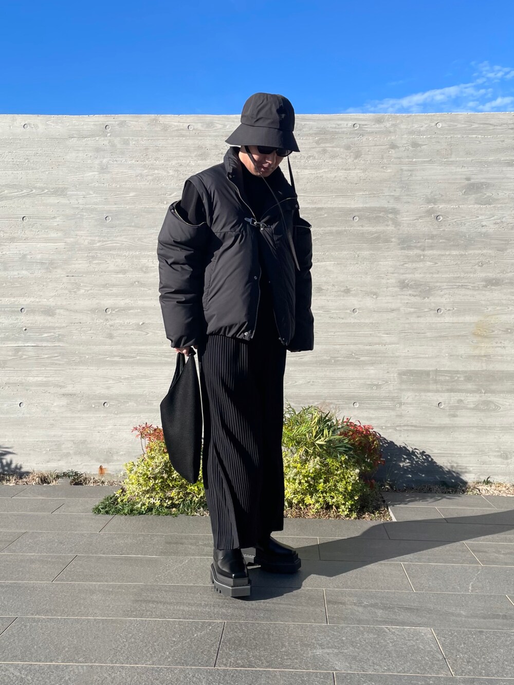 ブラック系のその他アウター、ブラック系のトートバッグ、ブラック系のその他パンツを着用したメンズの秋コーディネートの2枚目の写真