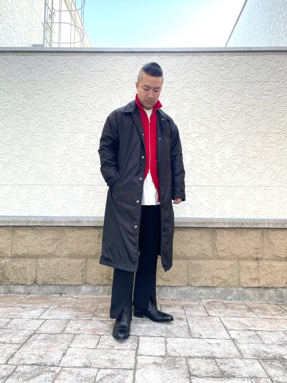 レッド系のニット/セーター、ブラック系のジャケット/アウター、ブラック系のその他パンツを着用したメンズの冬コーディネートの3枚目の写真