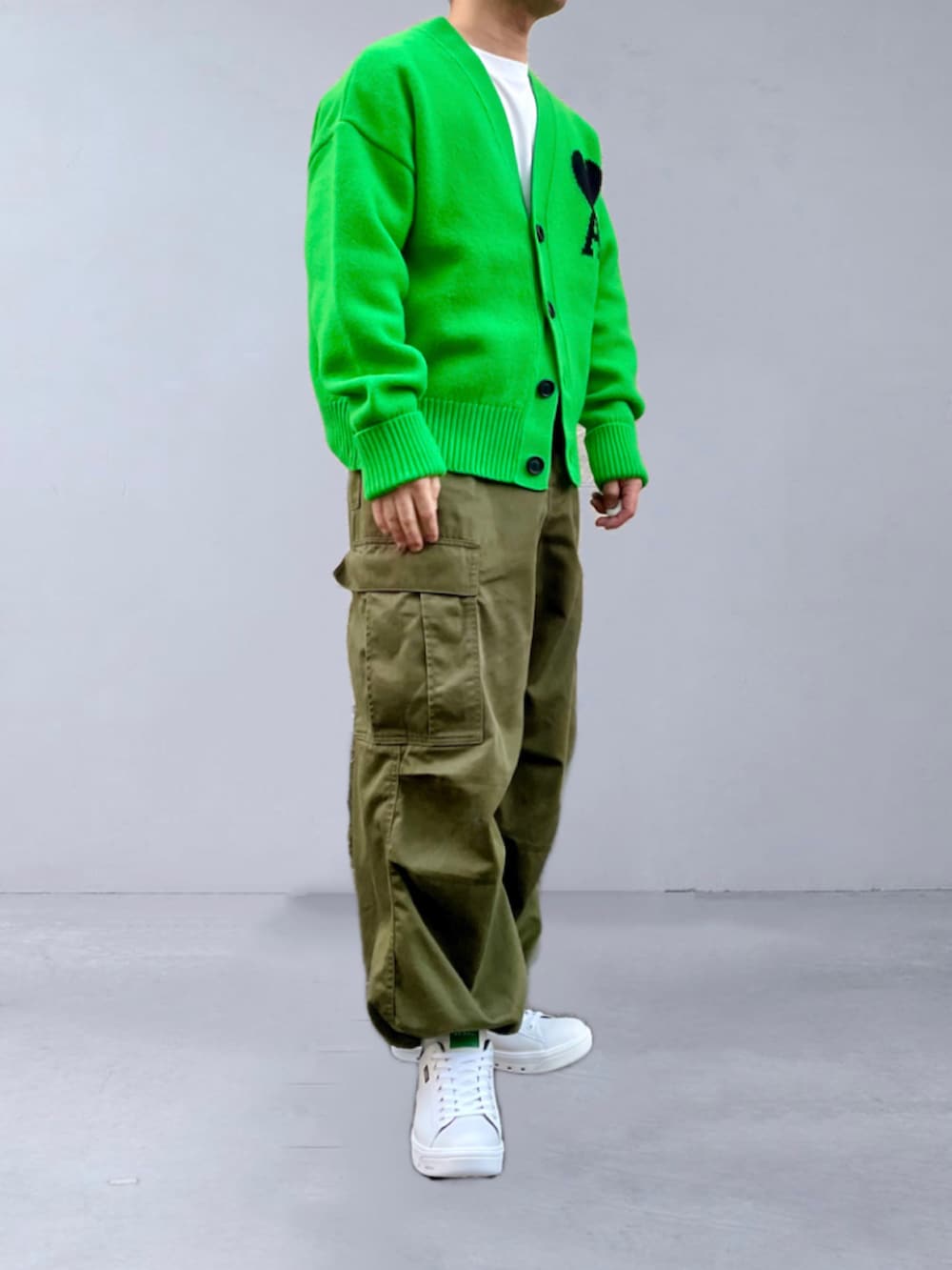 グリーン系のカーディガン/ボレロ、グリーン系のカーゴパンツ、ホワイト系のスニーカーを着用したメンズの秋コーディネートの2枚目の写真