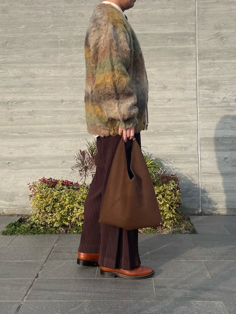 イエロー系のカーディガン/ボレロ、ブラウン系のその他パンツ、ブラウン系のバッグを着用したメンズの冬コーディネートの4枚目の写真