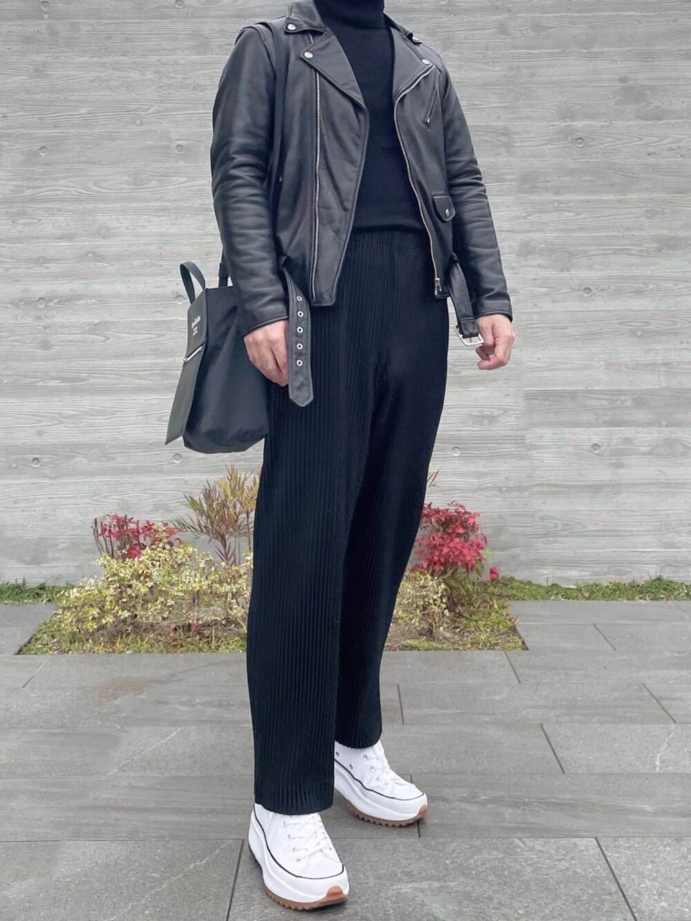 ブラック系のライダースジャケット、ブラウン系のニット/セーター、ブラック系のその他パンツを着用したメンズの冬コーディネートの2枚目の写真