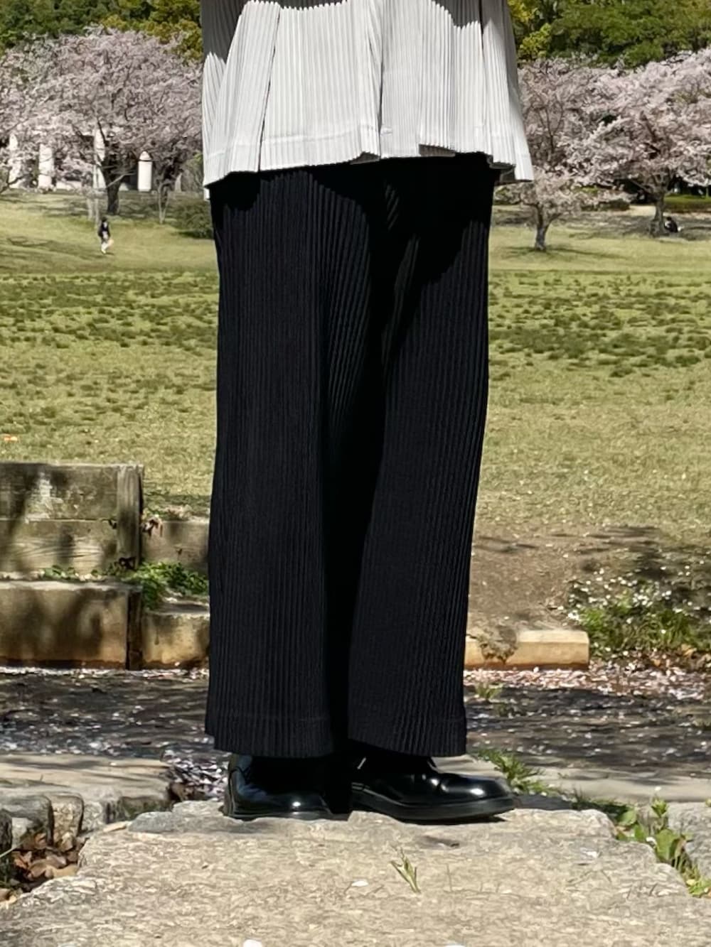 グレー系のベスト、ブラック系のその他パンツ、ホワイト系のTシャツ/カットソーを着用したメンズの春コーディネートの4枚目の写真