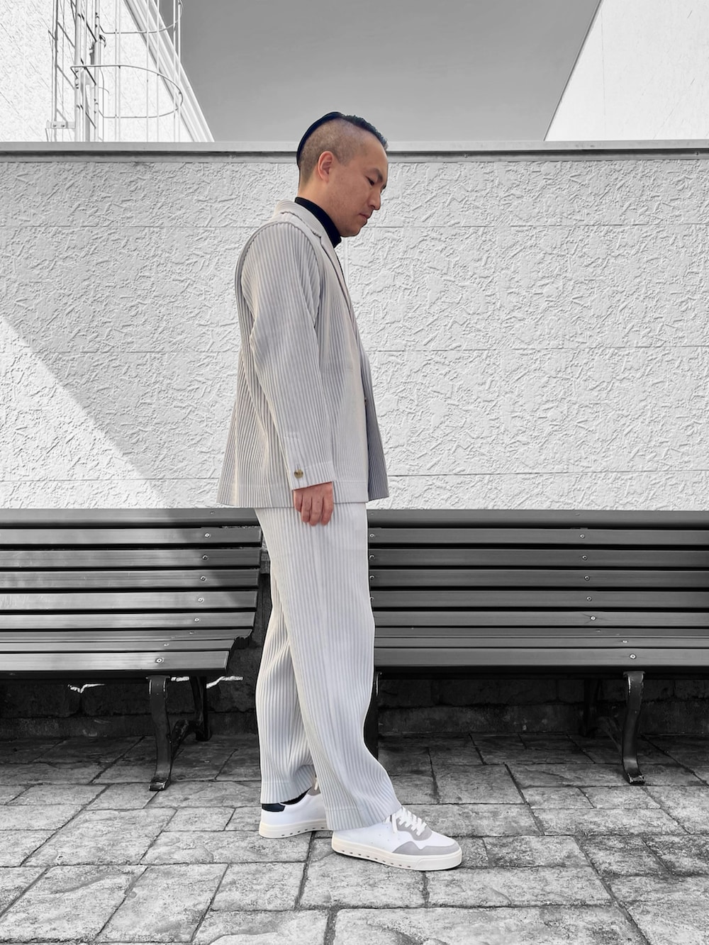 ホワイト系のスニーカー、グレー系のテーラードジャケット、グレー系のその他パンツを着用したメンズの冬コーディネートの2枚目の写真