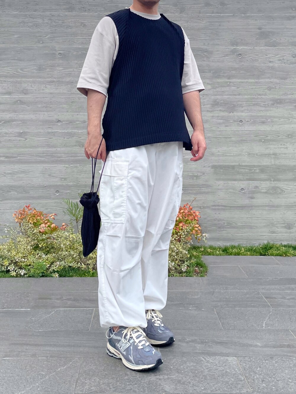 ブラック系のベスト、ブラック系のショルダーバッグ、グレー系のスニーカーを着用したメンズの秋コーディネートの2枚目の写真