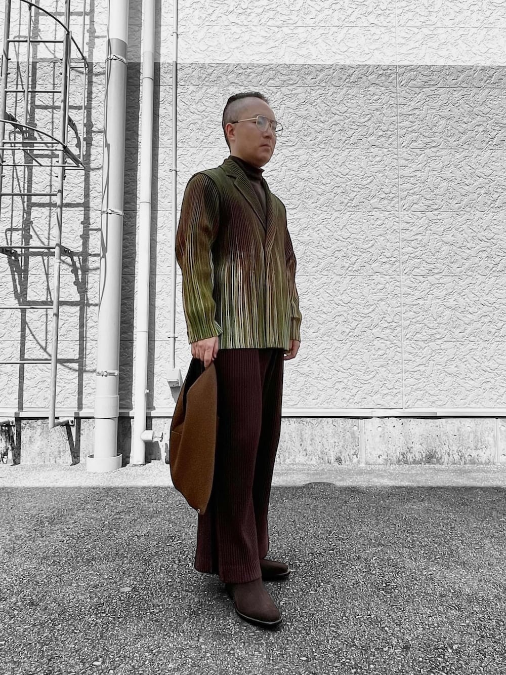 グリーン系のテーラードジャケット、ブラウン系のその他パンツ、ブラウン系のバッグを着用したメンズの春コーディネートの3枚目の写真