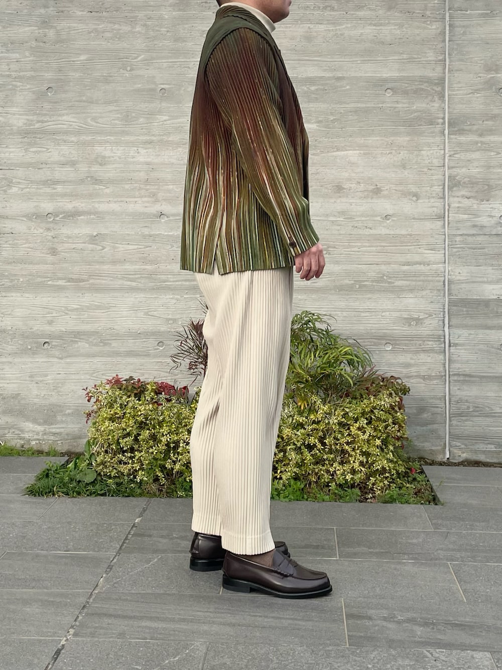 グリーン系のテーラードジャケット、ベージュ系のスラックス、ブラウン系のローファーを着用したメンズの春コーディネートの3枚目の写真