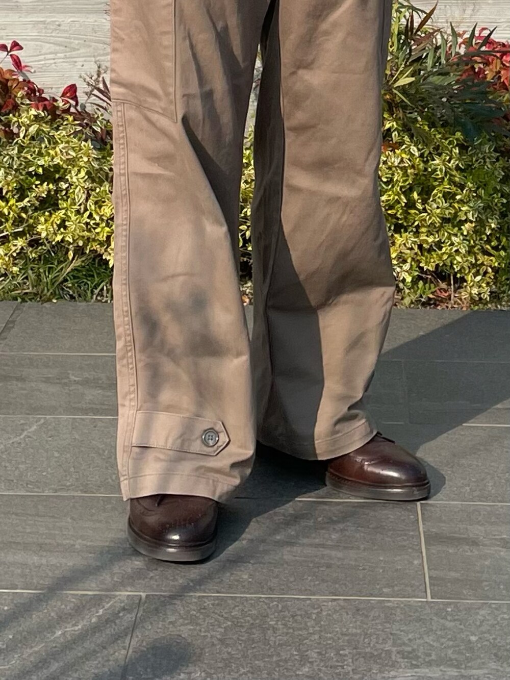 ブラウン系のTシャツ/カットソー、グリーン系のカーゴパンツ、ブラウン系のドレスシューズを着用したメンズの春コーディネートの4枚目の写真