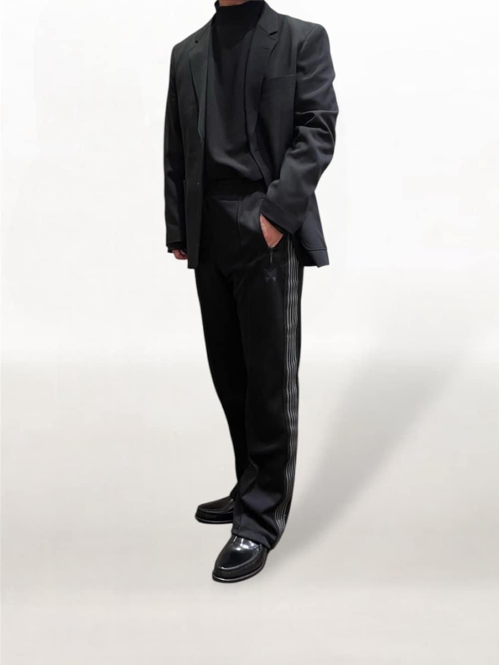 ブラック系のローファー、ブラック系のその他パンツ、ブラック系のテーラードジャケットを着用したメンズの冬コーディネートの3枚目の写真