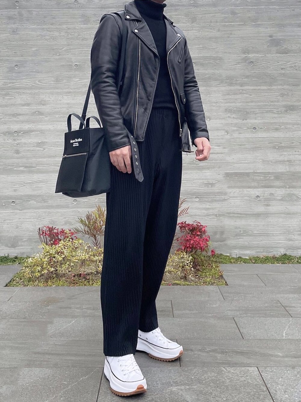 ブラック系のライダースジャケット、ブラウン系のニット/セーター、ブラック系のその他パンツを着用したメンズの冬コーディネートの3枚目の写真