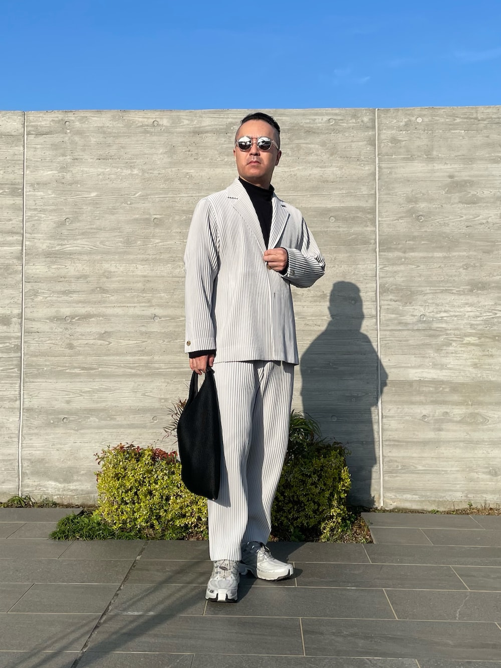 グレー系のその他パンツ、グレー系のテーラードジャケット、ブラック系のトートバッグを着用したメンズの春コーディネートの3枚目の写真