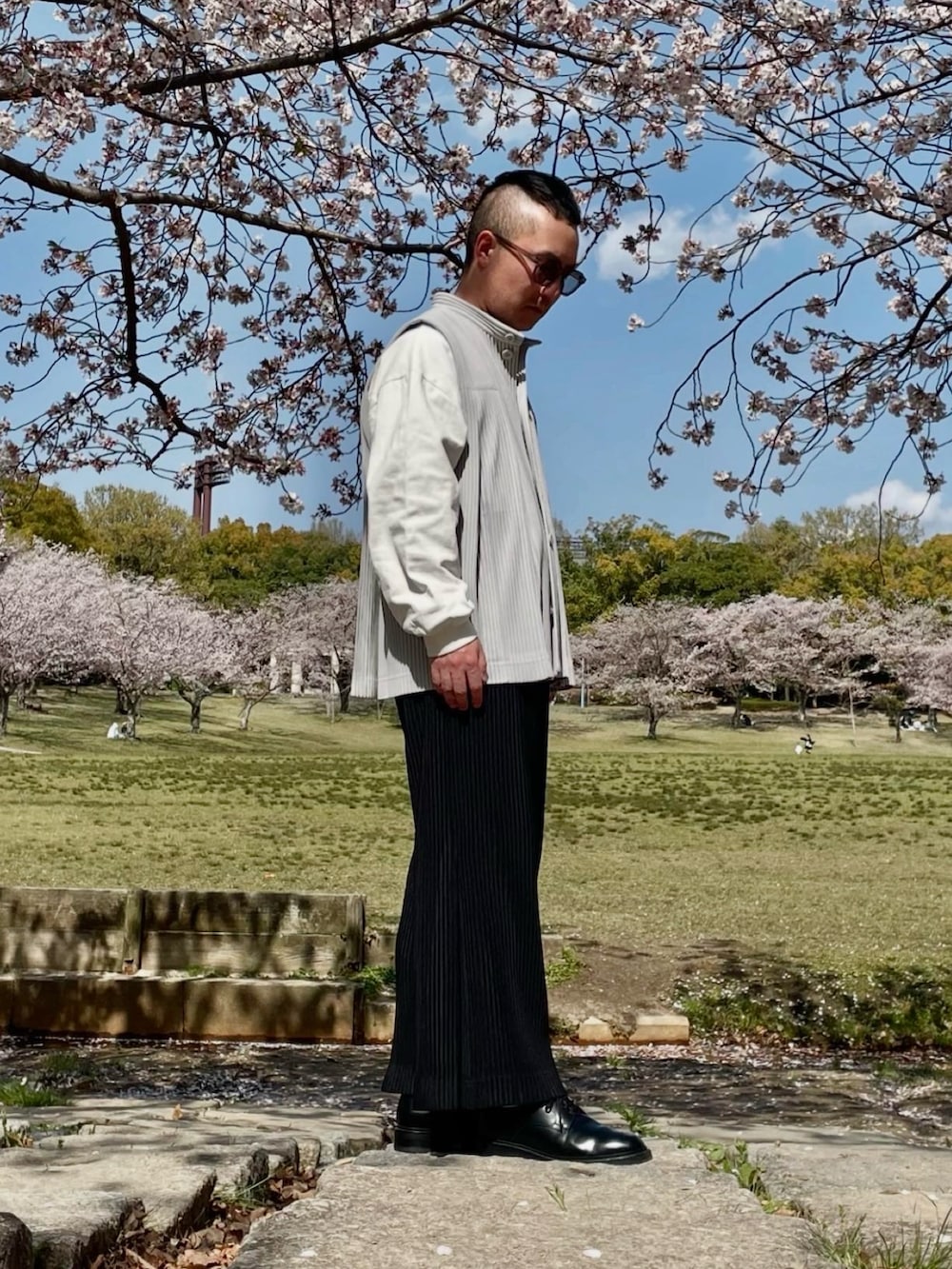 グレー系のベスト、ブラック系のその他パンツ、ホワイト系のTシャツ/カットソーを着用したメンズの春コーディネートの3枚目の写真