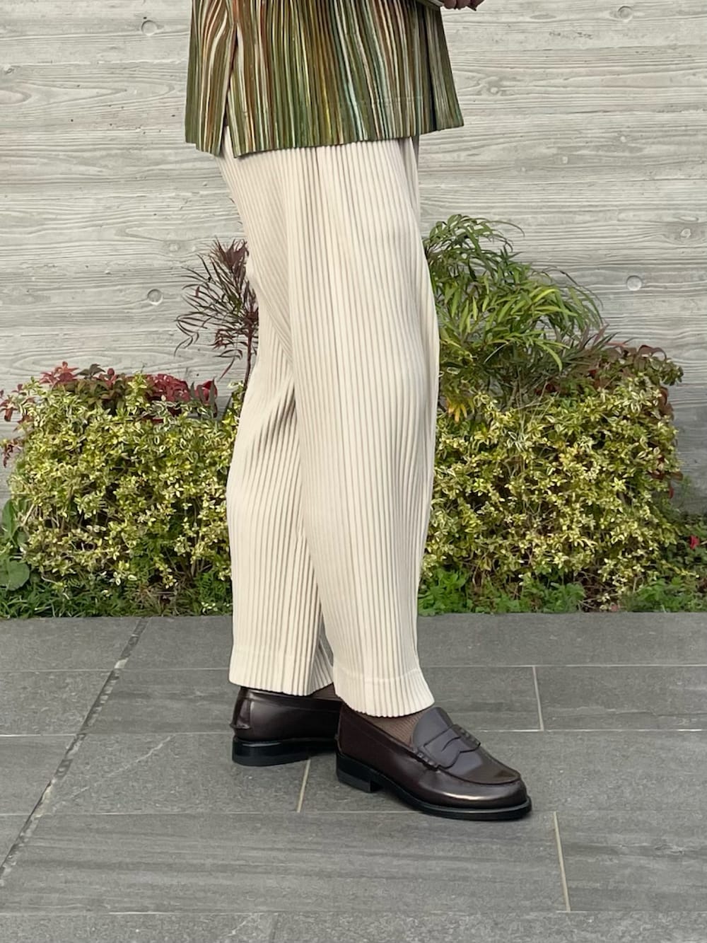 グリーン系のテーラードジャケット、ベージュ系のスラックス、ブラウン系のローファーを着用したメンズの春コーディネートの4枚目の写真