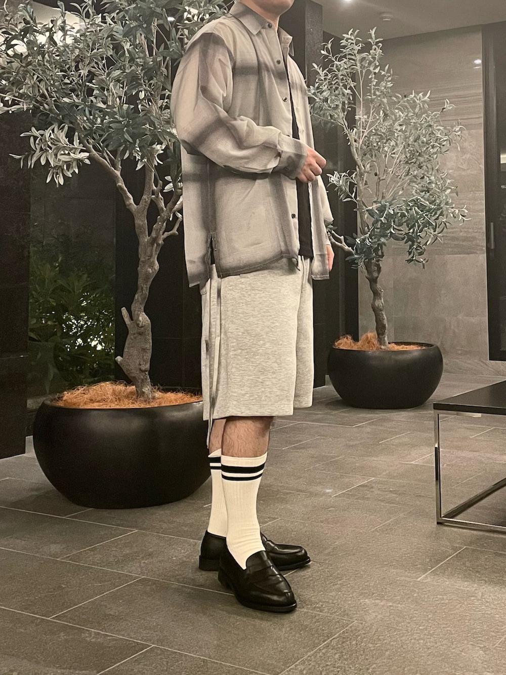 ホワイト系のシャツ/ブラウス、グレー系のスウェットパンツ、ブラック系のローファーを着用したメンズの夏コーディネートの2枚目の写真