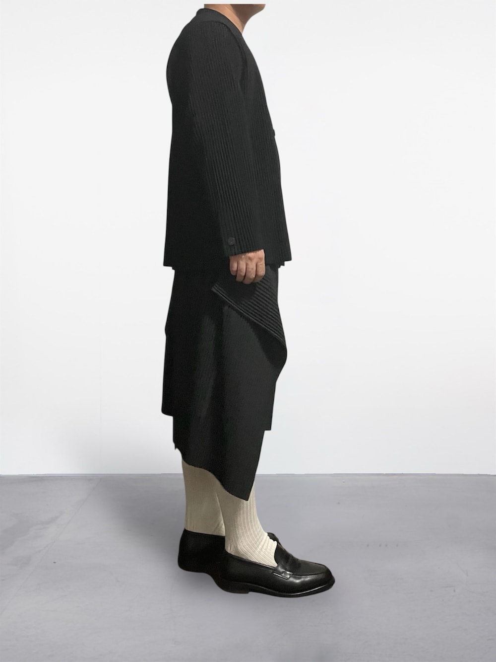 ブラック系のテーラードジャケット、ブラック系のスカート、ブラック系のローファーを着用したメンズの夏コーディネートの3枚目の写真