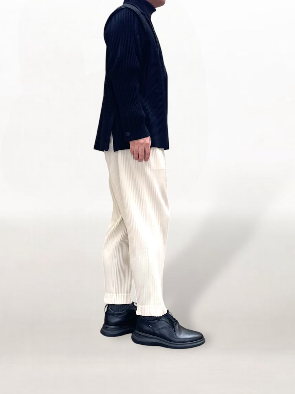 ブラック系のテーラードジャケット、ホワイト系のスラックス、ブラック系のスニーカーを着用したメンズの冬コーディネートの3枚目の写真