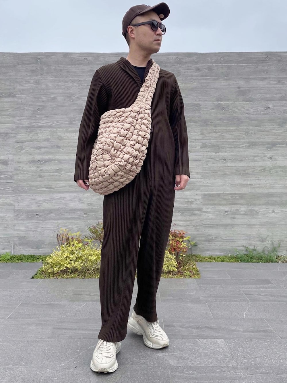 ブラウン系のつなぎ/オールインワン、ベージュ系のバッグ、ホワイト系のスニーカーを着用したメンズの春コーディネートの4枚目の写真