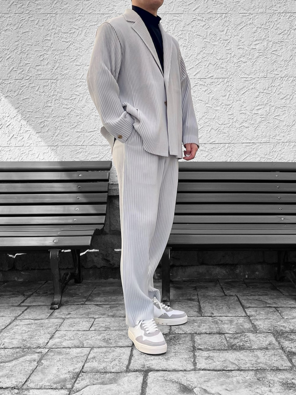 ホワイト系のスニーカー、グレー系のテーラードジャケット、グレー系のその他パンツを着用したメンズの冬コーディネートの3枚目の写真