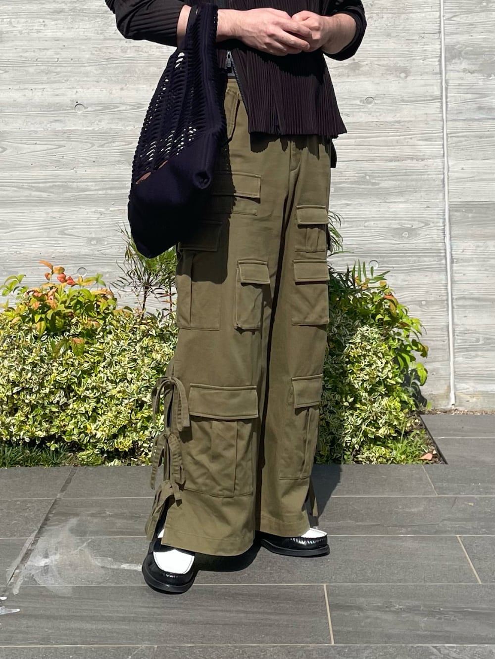 ブラック系のローファー、グリーン系のカーゴパンツ、ブラウン系のブルゾンを着用したメンズの夏コーディネートの3枚目の写真