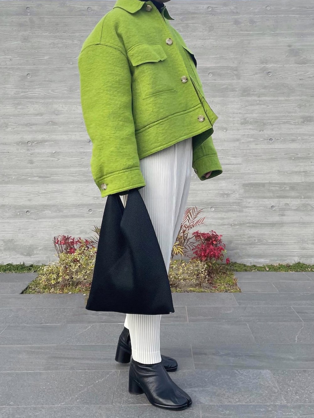 グリーン系のブルゾン、ブラウン系のニット/セーター、ホワイト系のスラックスを着用したメンズの冬コーディネートの3枚目の写真