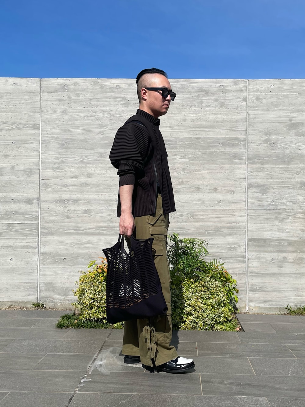 ブラック系のローファー、グリーン系のカーゴパンツ、ブラウン系のブルゾンを着用したメンズの夏コーディネートの2枚目の写真