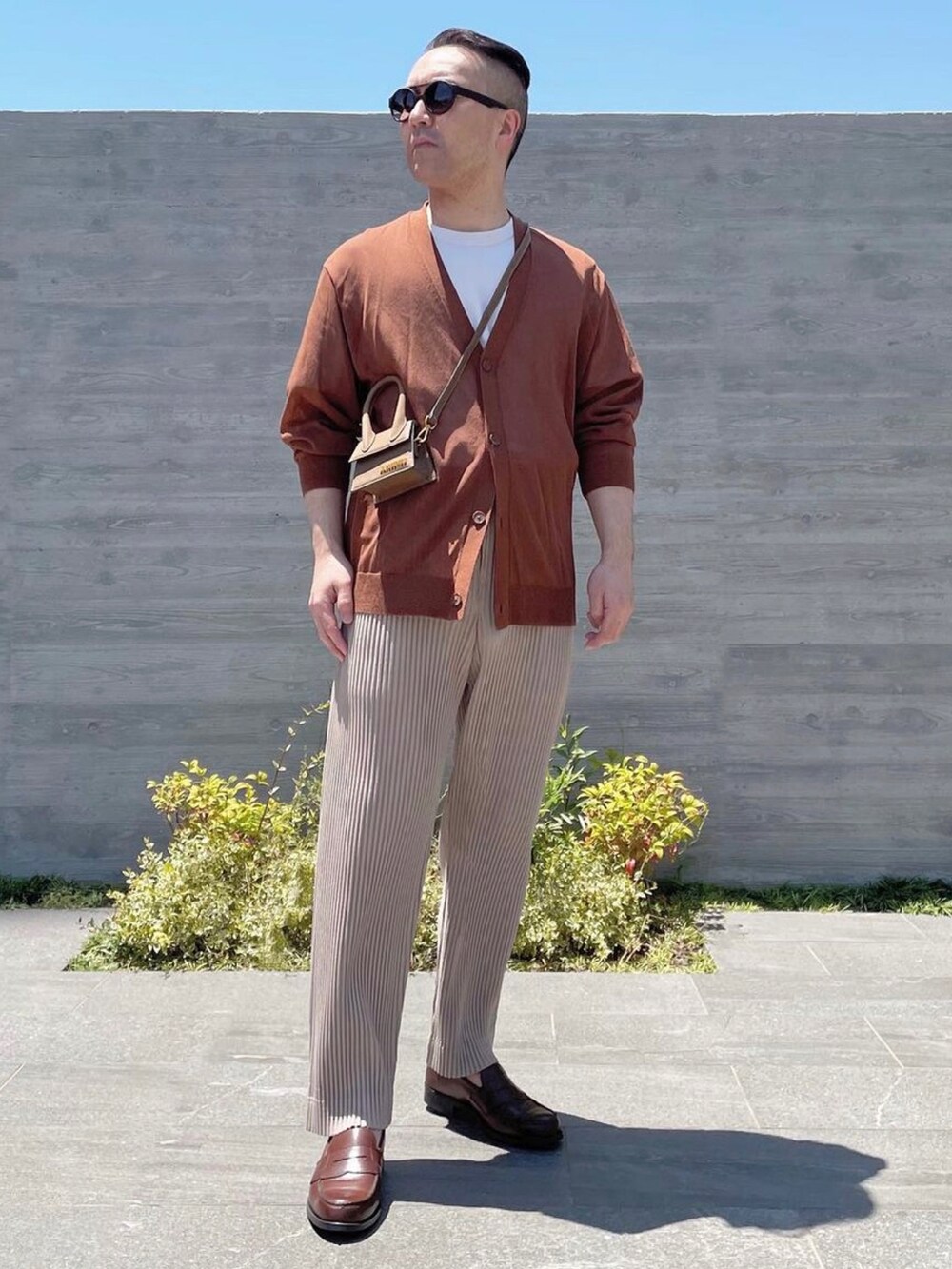 ブラウン系のバッグ、ベージュ系のその他パンツ、ブラウン系のスリッポンを着用したメンズの春コーディネートの2枚目の写真