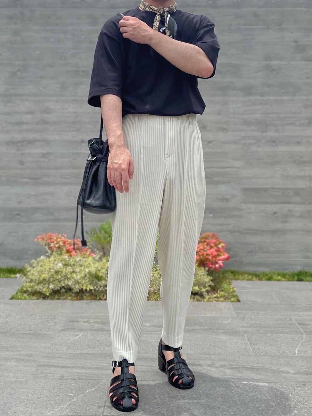 ブラック系のTシャツ/カットソー、ホワイト系のスラックス、ブラック系のショルダーバッグを着用したメンズの夏コーディネートの2枚目の写真