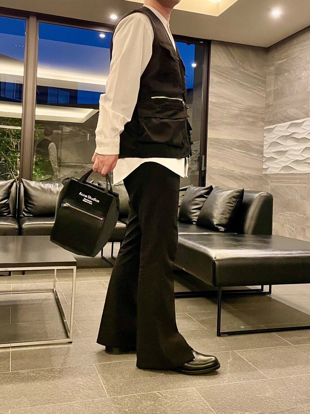 ブラック系のベスト、ブラック系のトートバッグ、ブラック系のその他パンツを着用したメンズの秋コーディネートの3枚目の写真