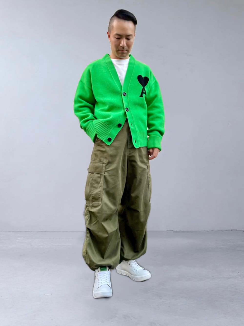 グリーン系のカーディガン/ボレロ、グリーン系のカーゴパンツ、ホワイト系のスニーカーを着用したメンズの秋コーディネートの3枚目の写真