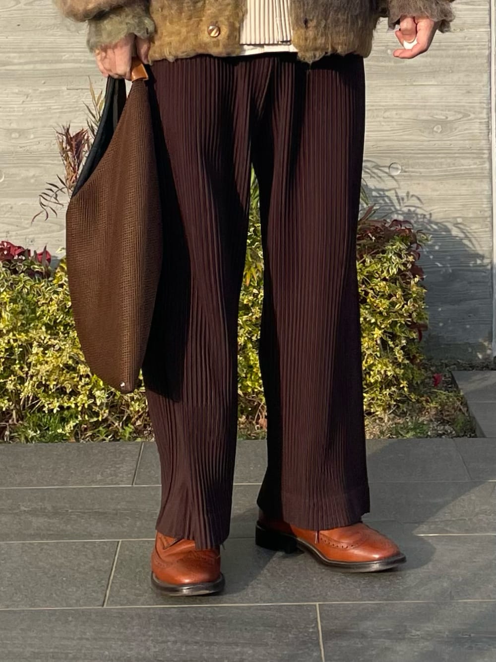 イエロー系のカーディガン/ボレロ、ブラウン系のその他パンツ、ブラウン系のバッグを着用したメンズの冬コーディネートの5枚目の写真