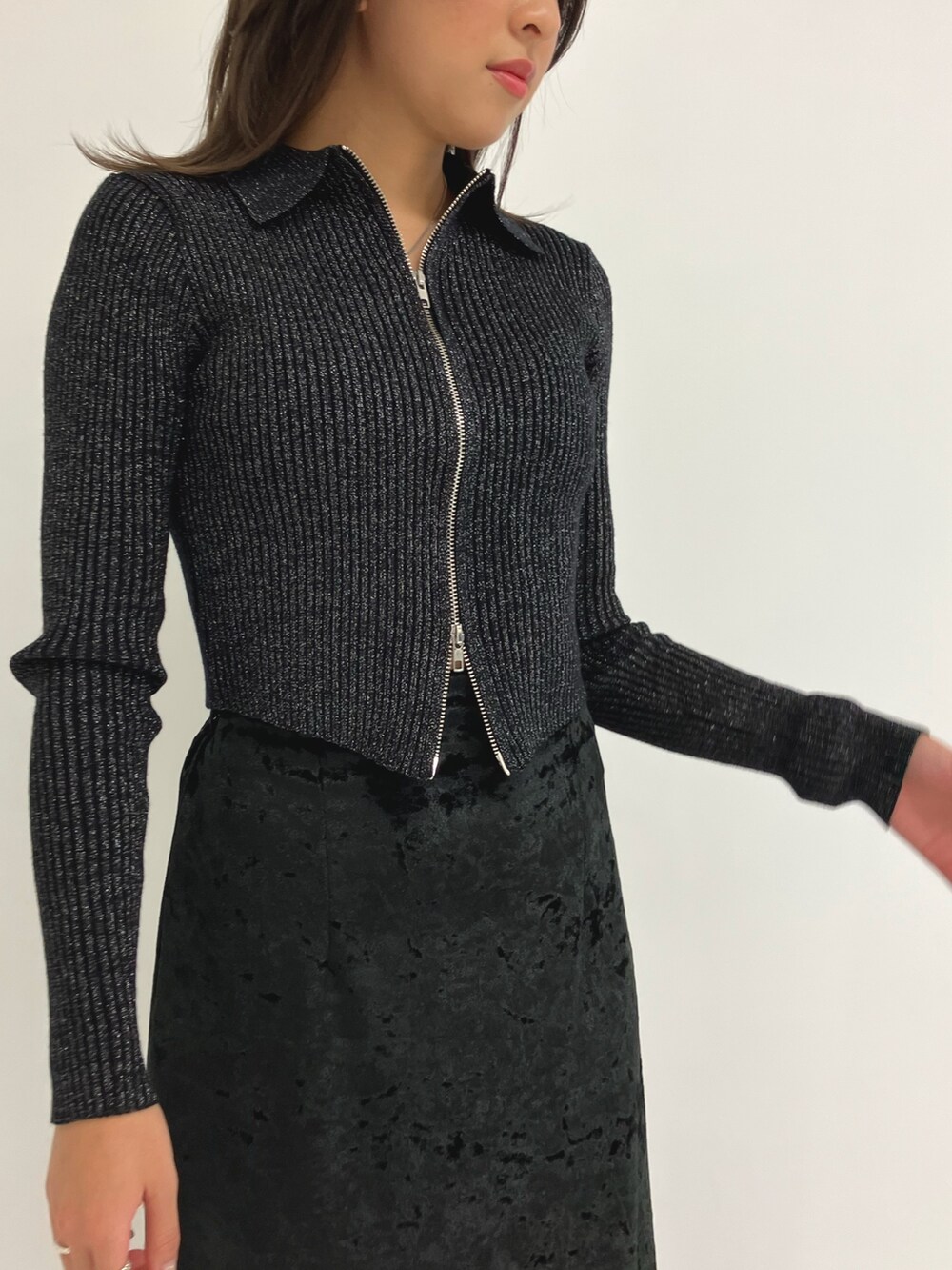 グレー系のニット/セーター、ブラック系のスカートを着用したレディースの秋コーディネートの3枚目の写真